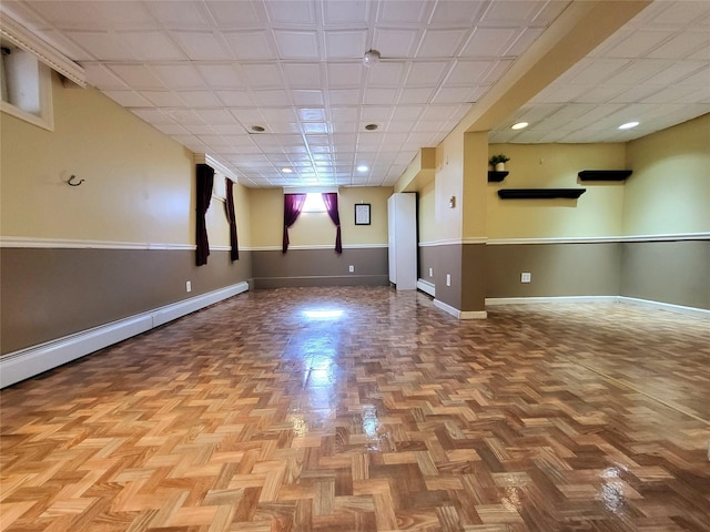 below grade area featuring a baseboard heating unit and baseboards