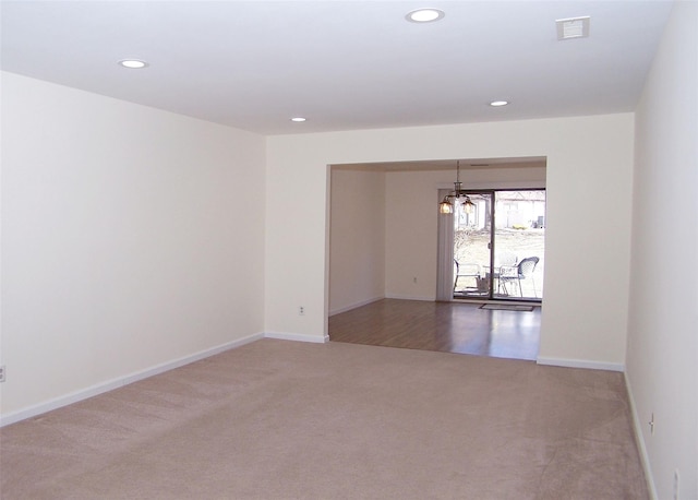 carpeted empty room featuring baseboards, visible vents, and recessed lighting