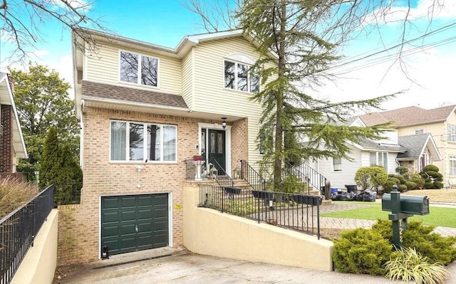 traditional-style home with a fenced front yard, an attached garage, brick siding, driveway, and roof with shingles