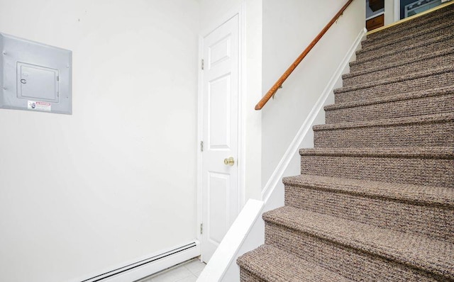 stairway featuring baseboard heating and electric panel