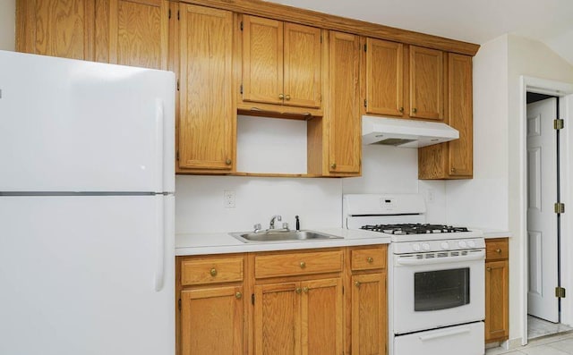 kitchen with white appliances, brown cabinetry, light countertops, under cabinet range hood, and a sink