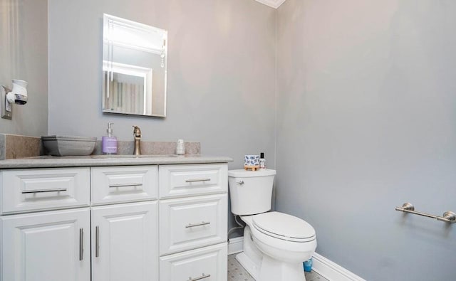 bathroom with vanity, toilet, and baseboards