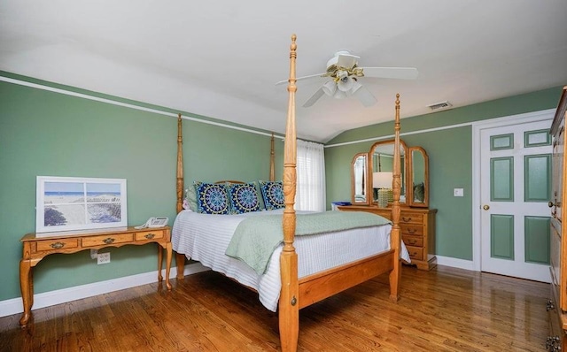 bedroom featuring lofted ceiling, wood finished floors, visible vents, and baseboards