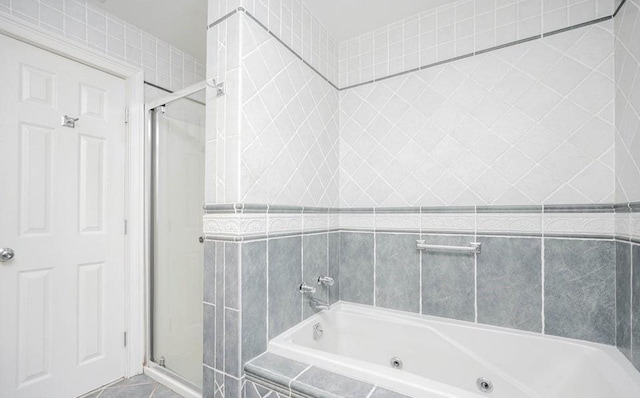 bathroom with tile patterned flooring, a shower stall, and a whirlpool tub