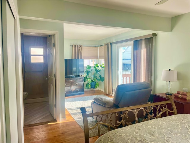 bedroom featuring multiple windows and wood finished floors