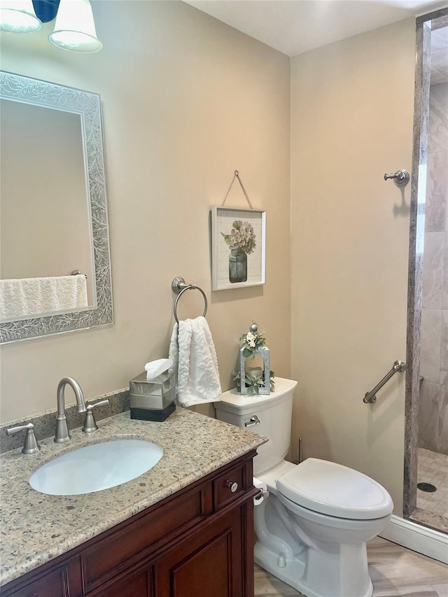 bathroom with a stall shower, vanity, and toilet