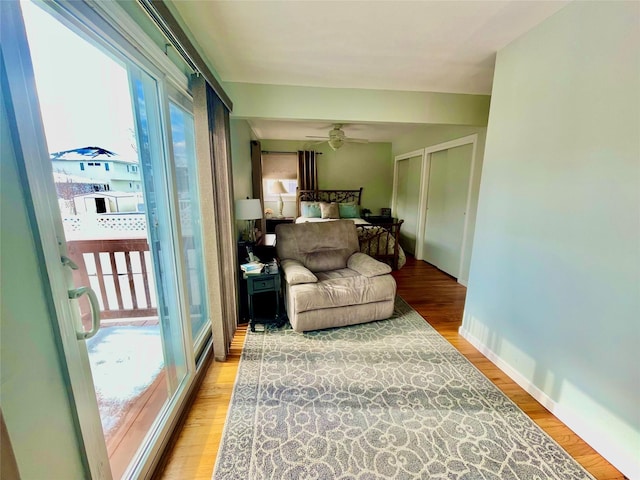 sitting room with a ceiling fan, plenty of natural light, and light wood-style flooring