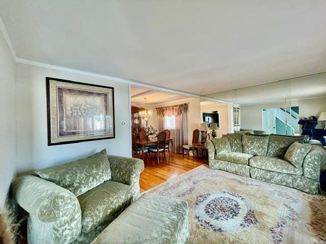 living room featuring crown molding, wood finished floors, and an inviting chandelier