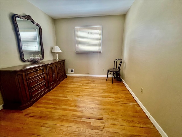 sitting room with light wood-style floors, visible vents, plenty of natural light, and baseboards