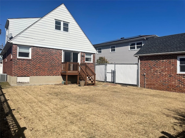 back of house with a gate, fence, a yard, central AC, and brick siding