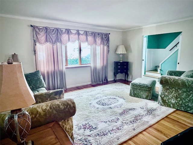 living room featuring baseboards, crown molding, and wood finished floors