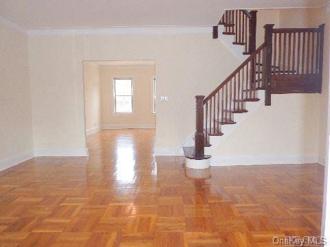 foyer with crown molding, baseboards, and stairs