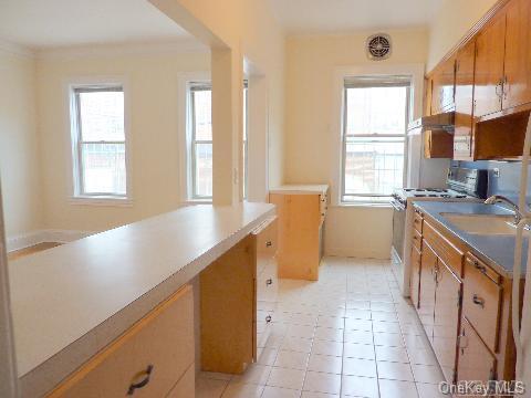 kitchen featuring white gas stove, a sink, a wealth of natural light, and brown cabinets