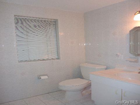 bathroom with vanity, toilet, and tile patterned floors