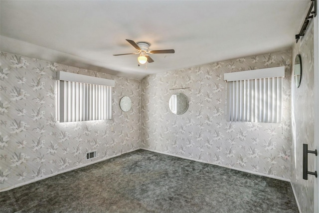 carpeted spare room with visible vents, baseboards, ceiling fan, and wallpapered walls