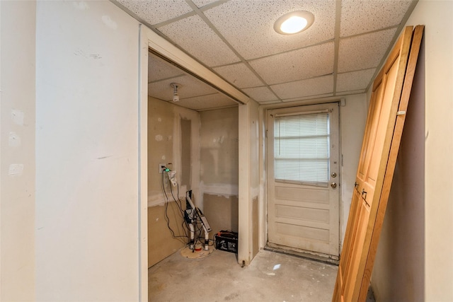 doorway to outside featuring a drop ceiling and concrete flooring