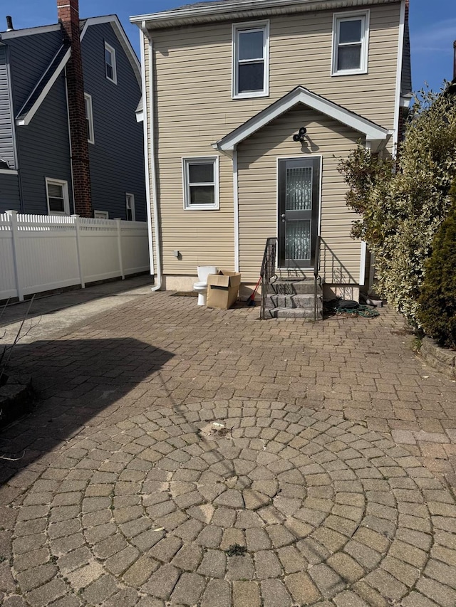 back of house featuring entry steps and fence