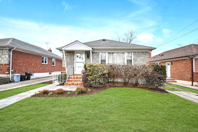 view of front of property with a front yard, stone siding, and roof with shingles