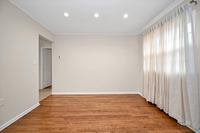 spare room featuring recessed lighting, baseboards, light wood-style floors, and ornamental molding