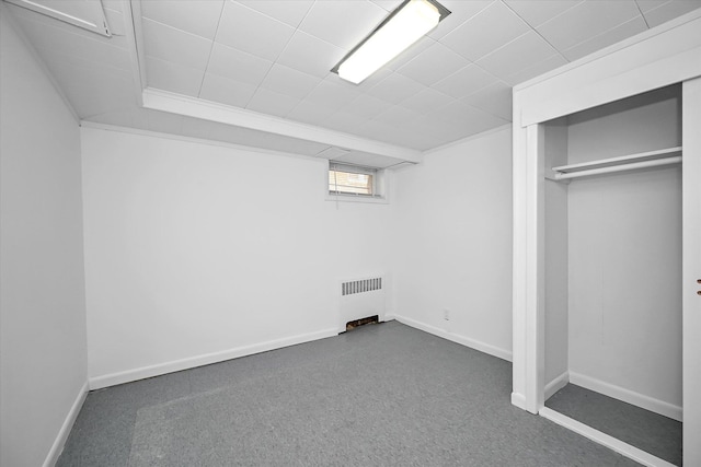 unfurnished bedroom featuring a closet, radiator, and baseboards