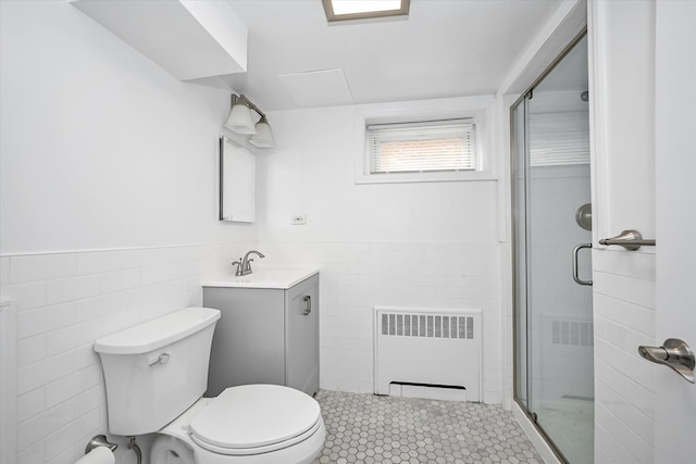 full bath featuring radiator heating unit, a stall shower, wainscoting, tile walls, and toilet