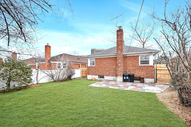 rear view of property with a patio, a fenced backyard, a chimney, a lawn, and brick siding