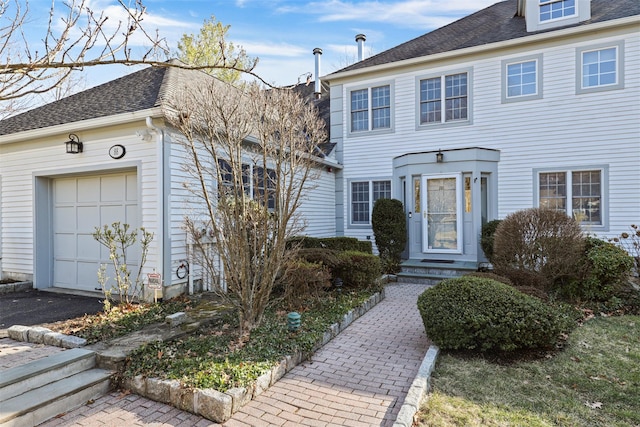 view of front facade featuring an attached garage and a shingled roof