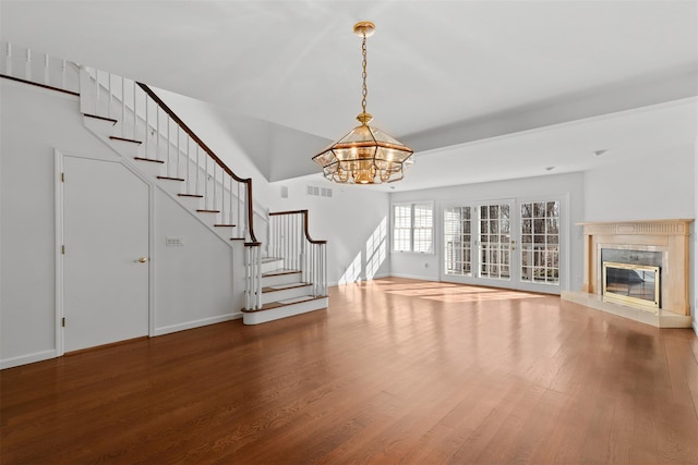 unfurnished living room featuring visible vents, wood finished floors, stairway, a premium fireplace, and baseboards