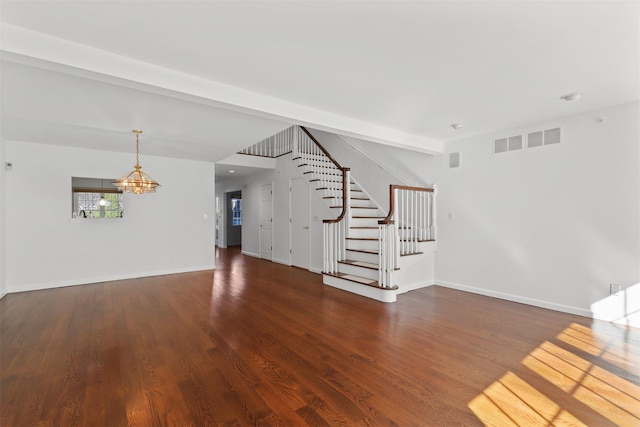 interior space featuring a notable chandelier, stairs, baseboards, and wood finished floors