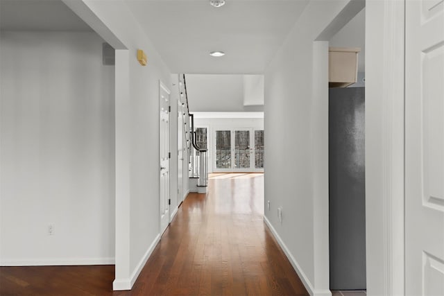 hallway with stairs, baseboards, and wood finished floors