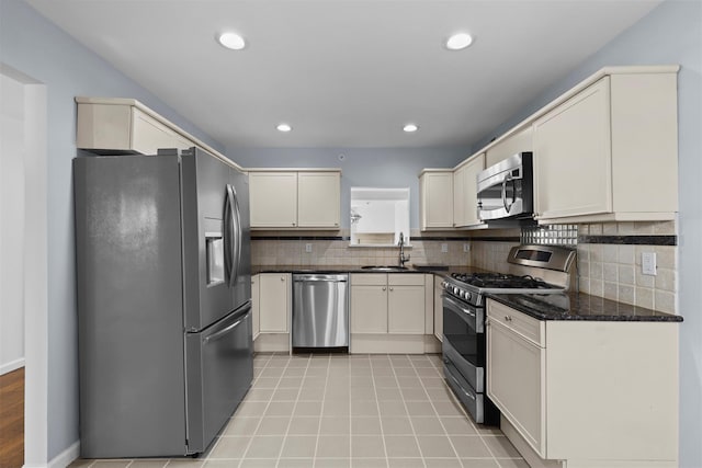 kitchen with light tile patterned floors, recessed lighting, a sink, appliances with stainless steel finishes, and backsplash