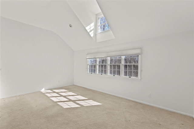 carpeted spare room with baseboards and lofted ceiling