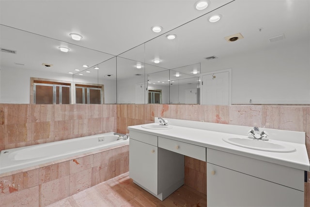 full bath with a sink, visible vents, and tile walls