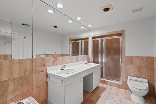 full bathroom featuring visible vents, a stall shower, a sink, tile walls, and toilet