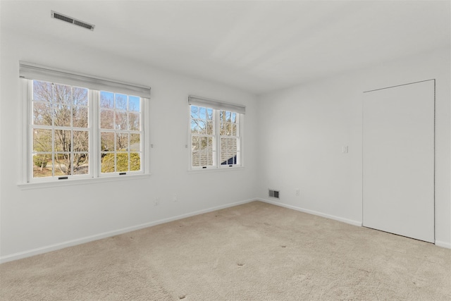 spare room featuring baseboards, visible vents, and carpet floors