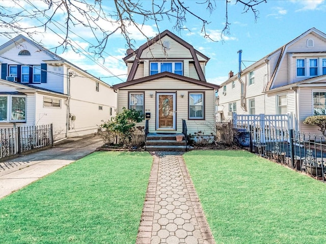 view of front of property with a front yard, fence, and a gambrel roof