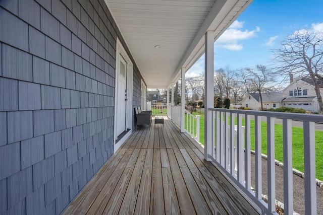 deck featuring a yard, a residential view, and covered porch