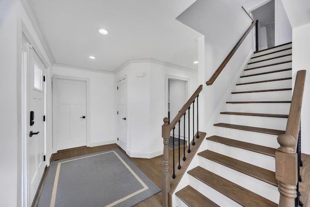 entrance foyer with wood finished floors, baseboards, recessed lighting, ornamental molding, and stairs