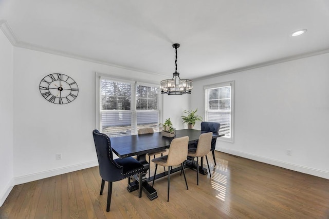 dining room featuring baseboards, wood-type flooring, an inviting chandelier, and ornamental molding