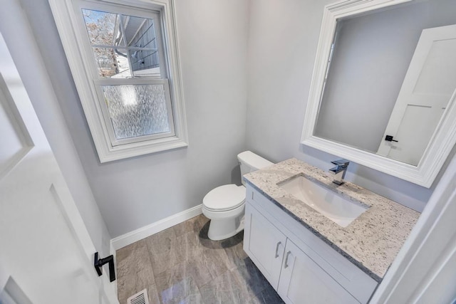 bathroom featuring vanity, wood finished floors, baseboards, visible vents, and toilet