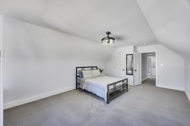 carpeted bedroom with baseboards and lofted ceiling