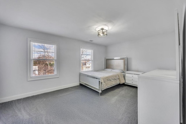 unfurnished bedroom featuring visible vents, baseboards, and dark colored carpet