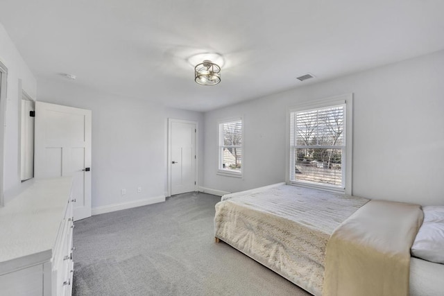 bedroom with light carpet, visible vents, and baseboards