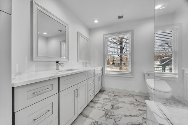 full bath with double vanity, baseboards, visible vents, and a sink