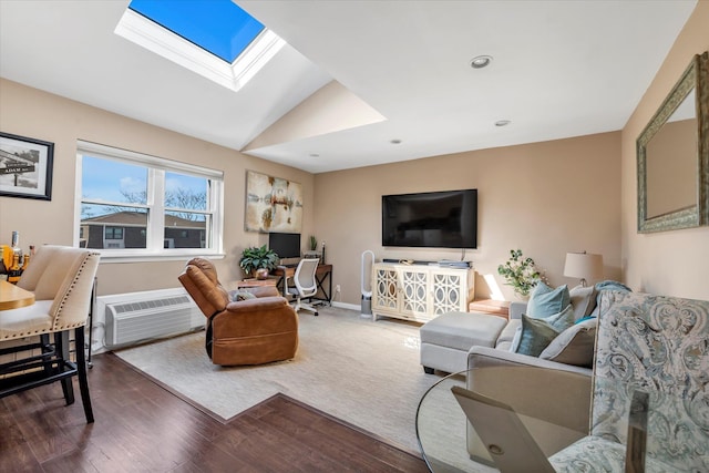 living area with baseboards, a wall unit AC, recessed lighting, vaulted ceiling with skylight, and wood finished floors