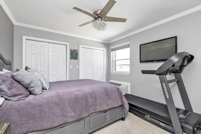 bedroom with multiple closets, ornamental molding, a ceiling fan, and a wall unit AC