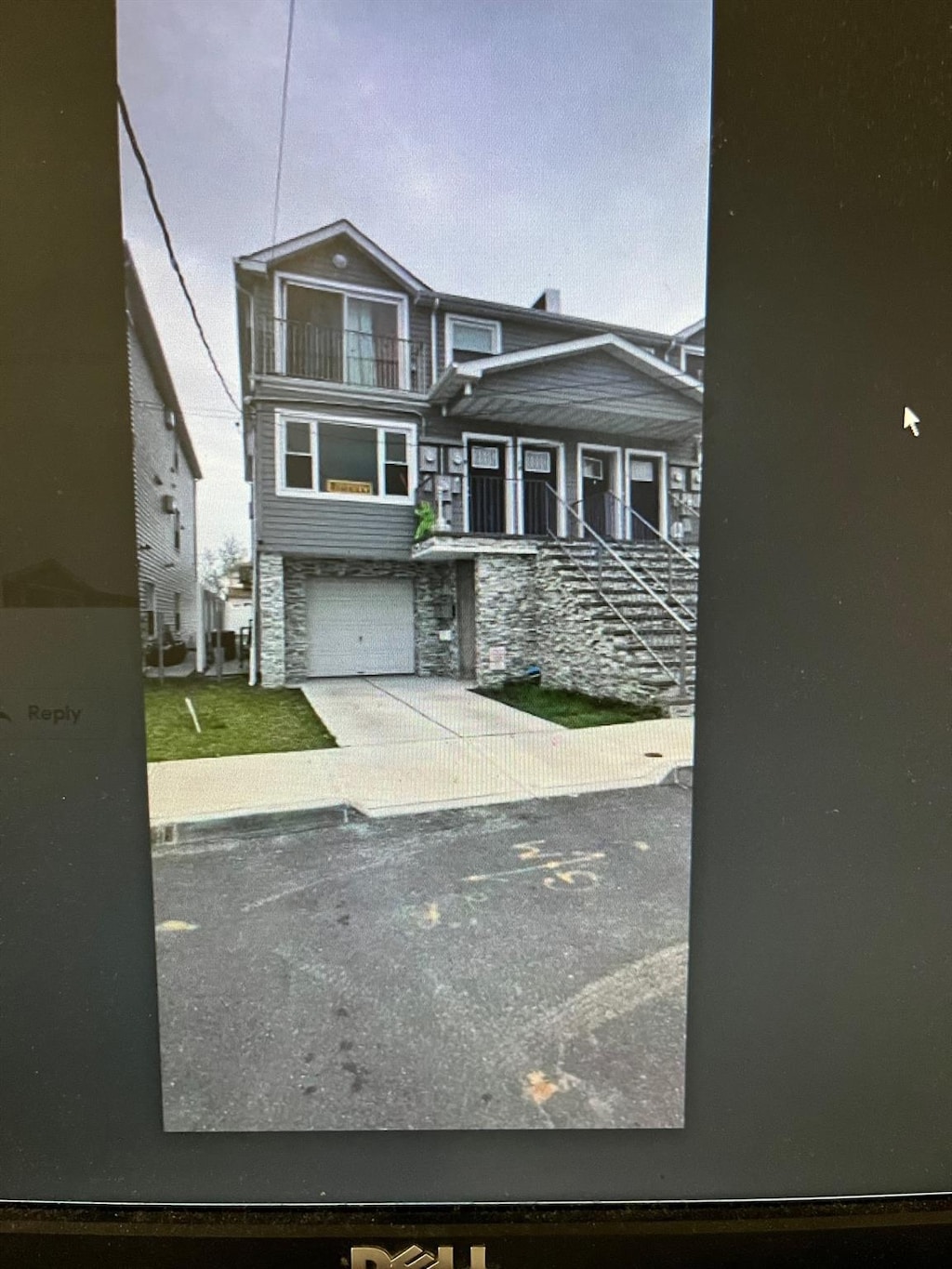 view of front of property featuring a balcony, stone siding, and a garage