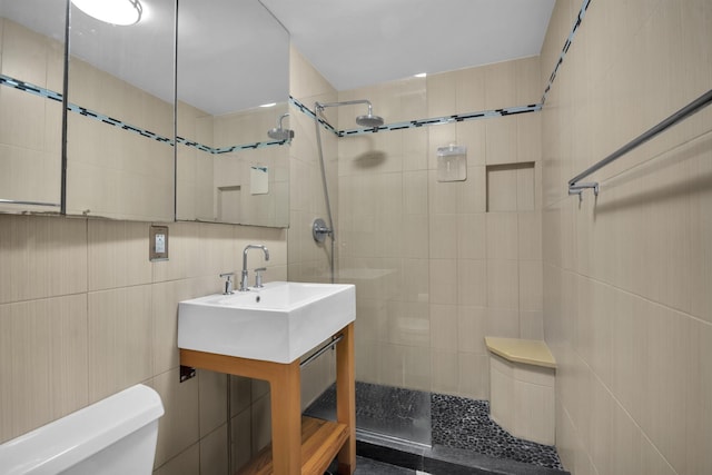 bathroom with vanity, toilet, tile walls, and walk in shower