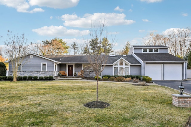 view of front of home with a garage, stone siding, a front lawn, and driveway