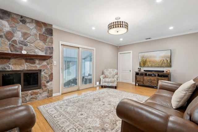 living area featuring visible vents, crown molding, recessed lighting, a fireplace, and wood finished floors